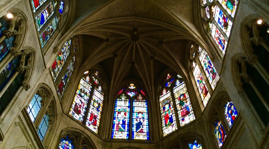 Admire gothic vault and medieval stained glass windows